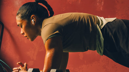 Una mujer haciendo ejercicio con los AirPods Pro 3